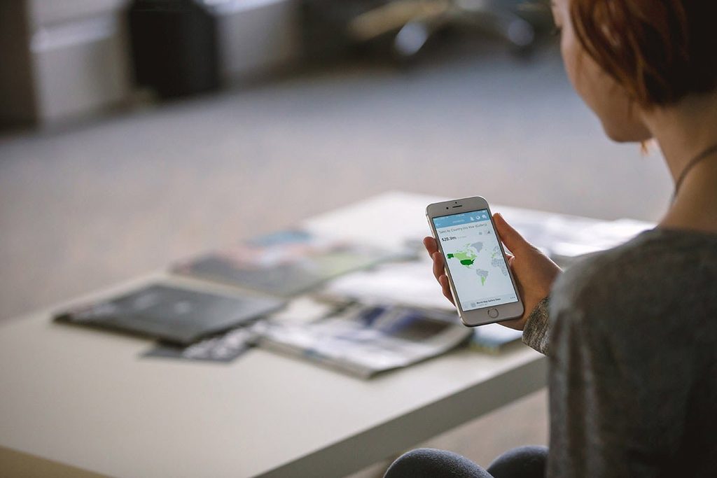 Person am Tisch mit Smartphone